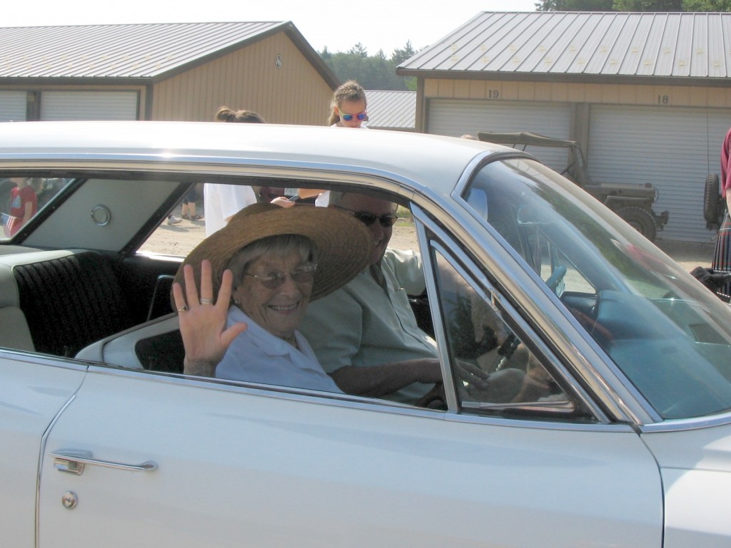 "Queen Alice" waves from the seat of Thom Thomas's 1964 Cadillac.