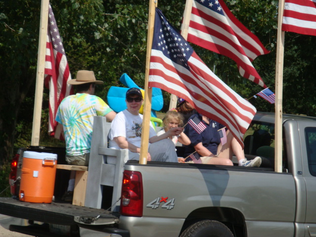 Will Townsend's flag-decked truck carried riders on an old church pew.